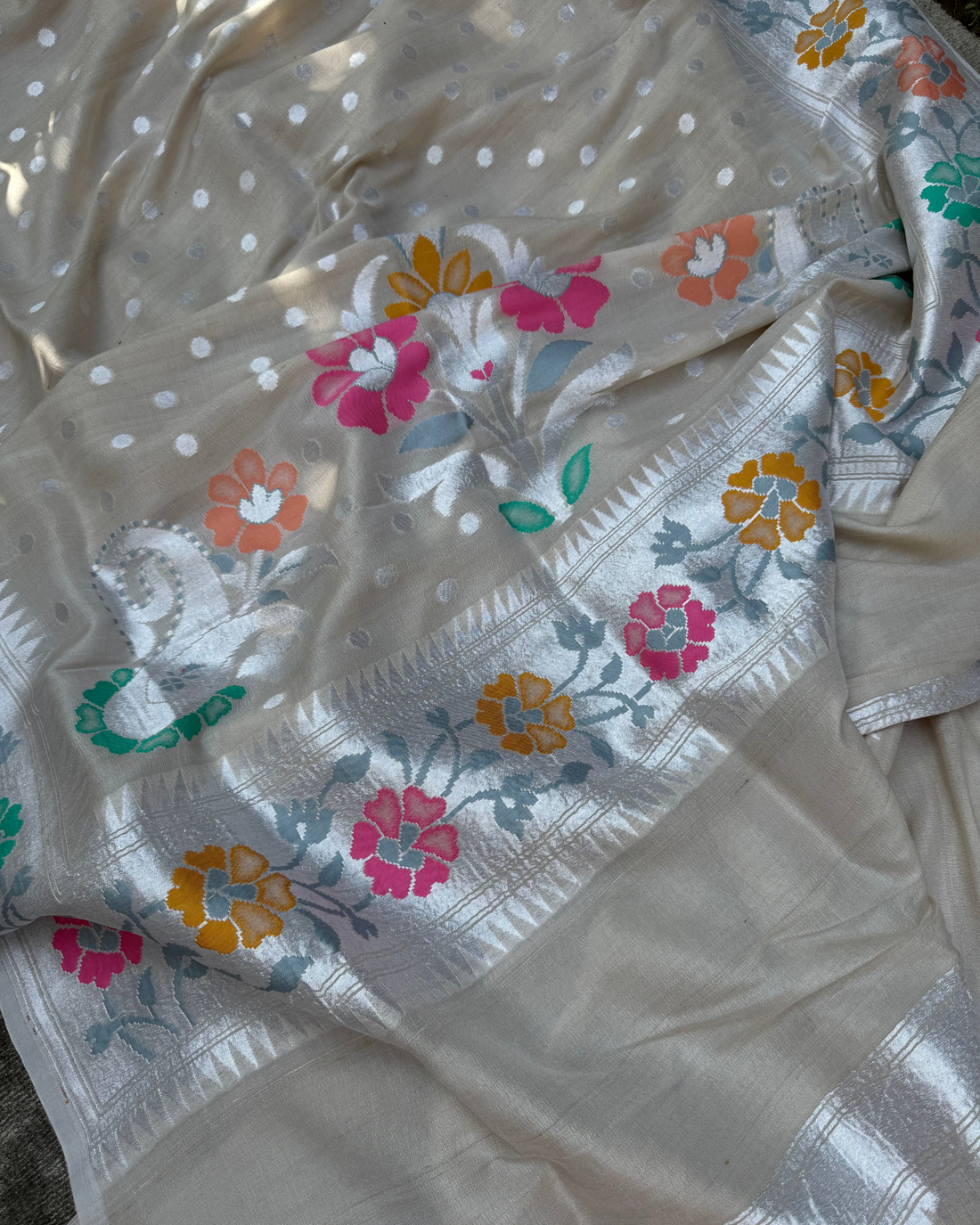 Elegant border detailing with fine metallic weave on ash white saree