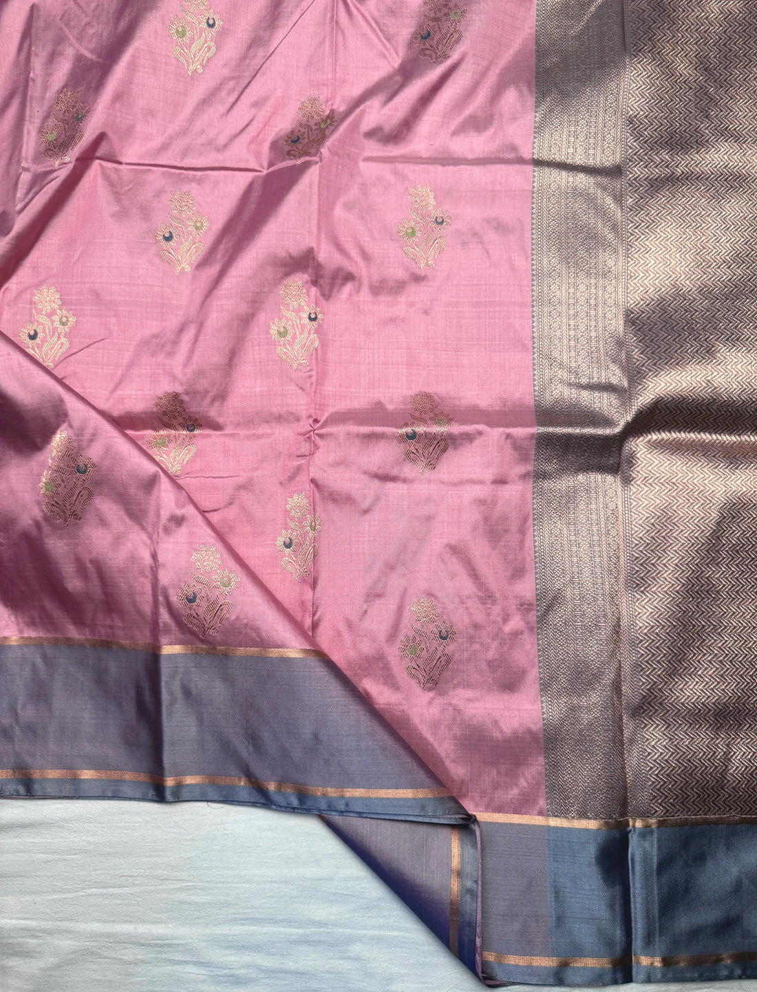 Close-up of floral Kadwa butis in water gold zari on pink silk