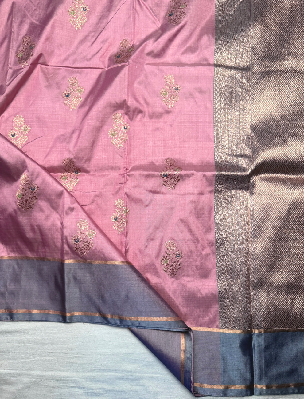 Close-up of floral Kadwa butis in water gold zari on pink silk