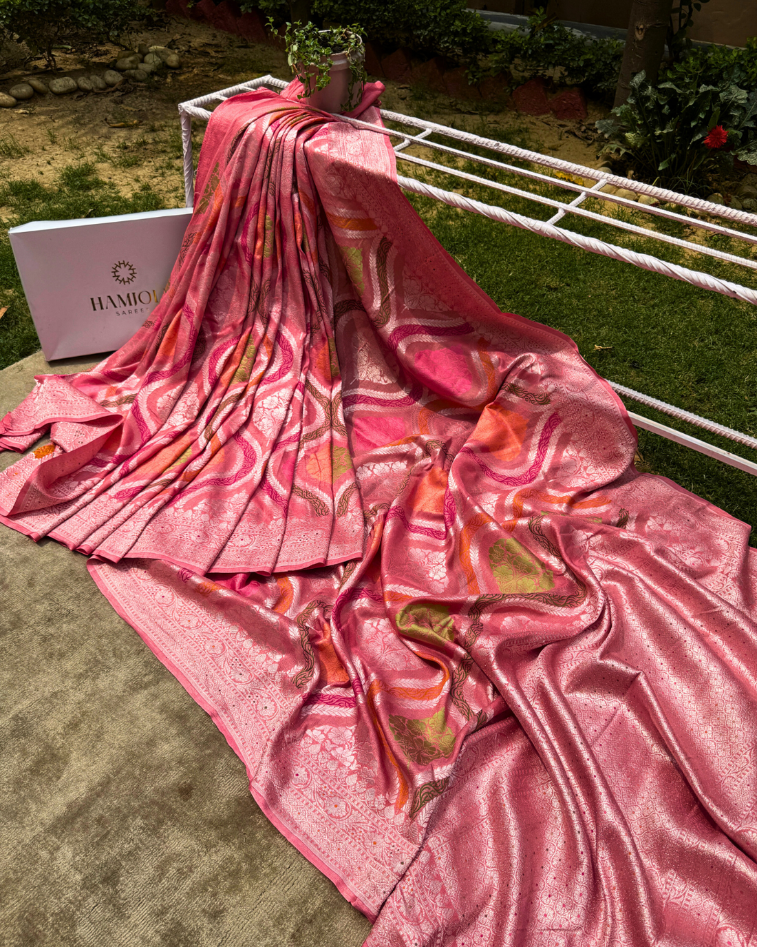 Close-up of silver zari and Meenakari floral motifs on dusty pink Georgette saree
