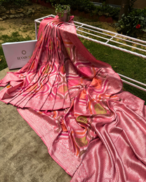 Close-up of silver zari and Meenakari floral motifs on dusty pink Georgette saree