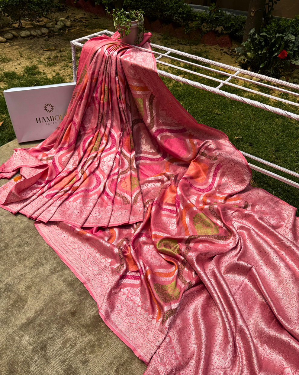 Close-up of silver zari and Meenakari floral motifs on dusty pink Georgette saree