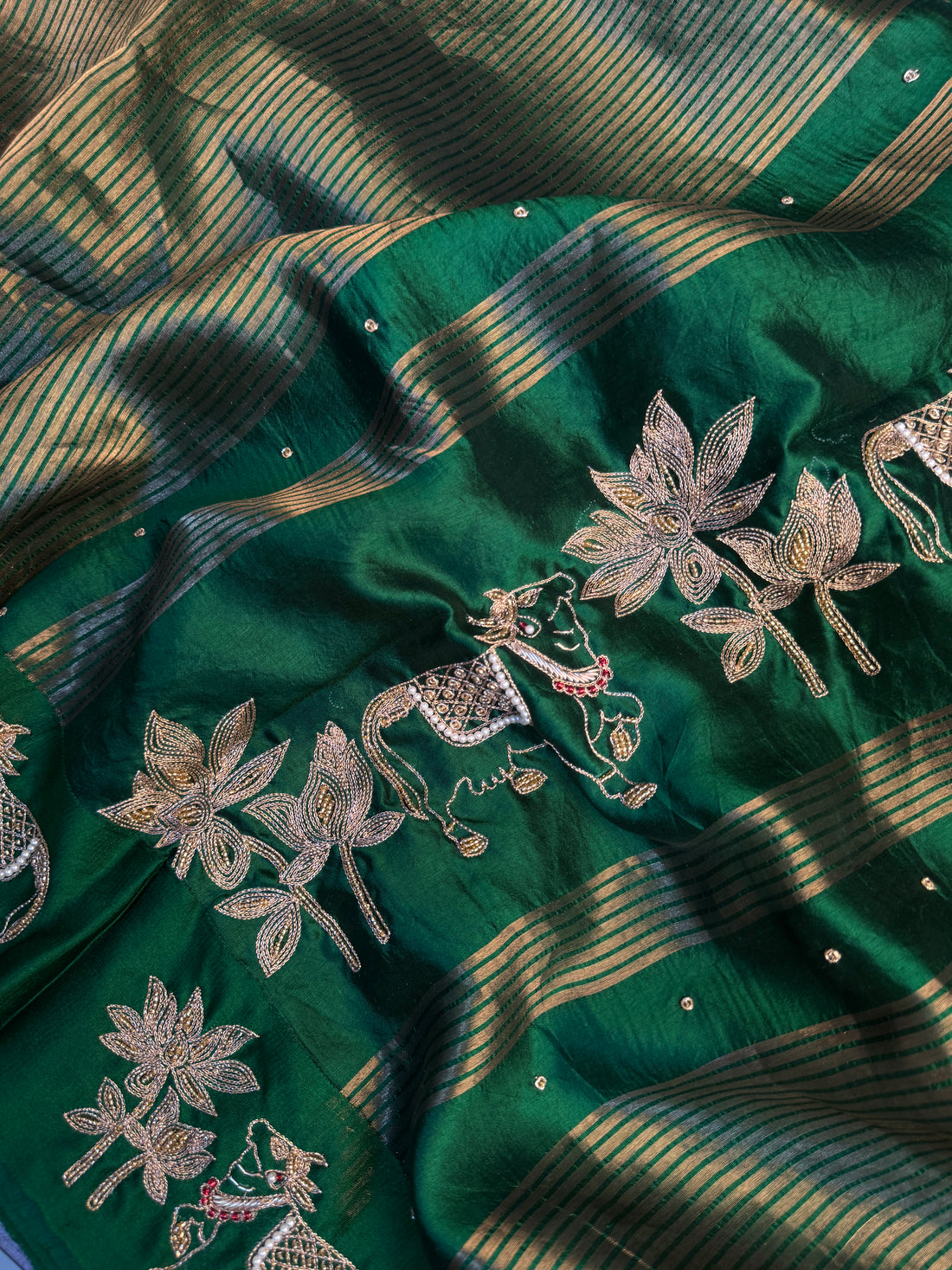 Kamdhenu and lotus motif border in hand Zardozi on emerald green pure silk saree