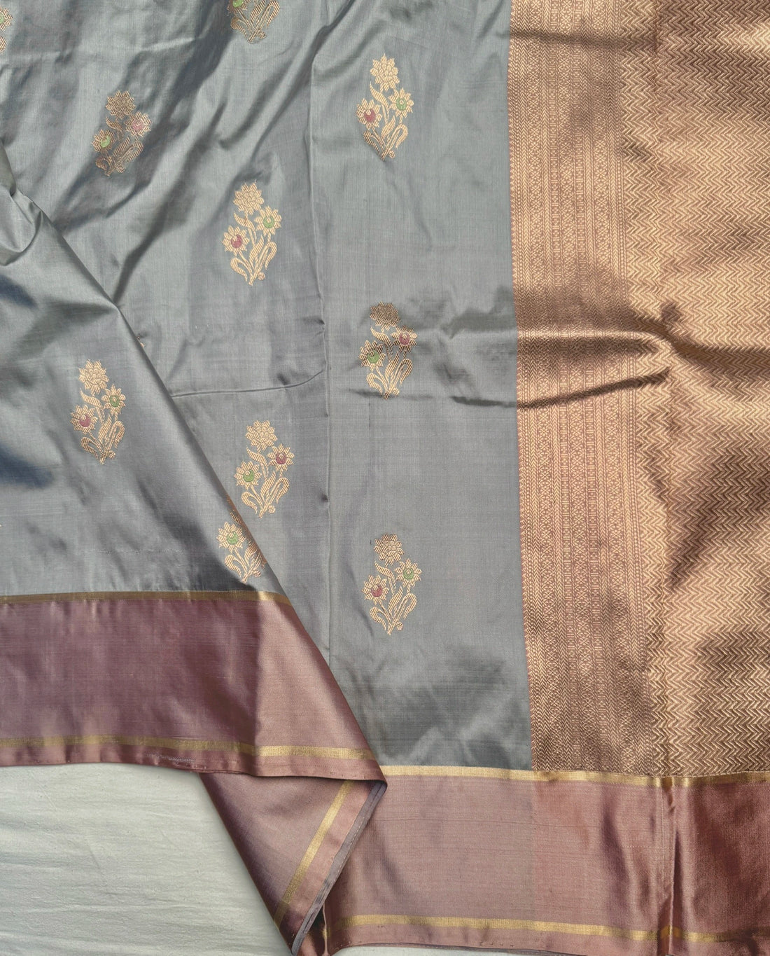Close-up of delicate water gold zari floral Kadwa butis on blue silk