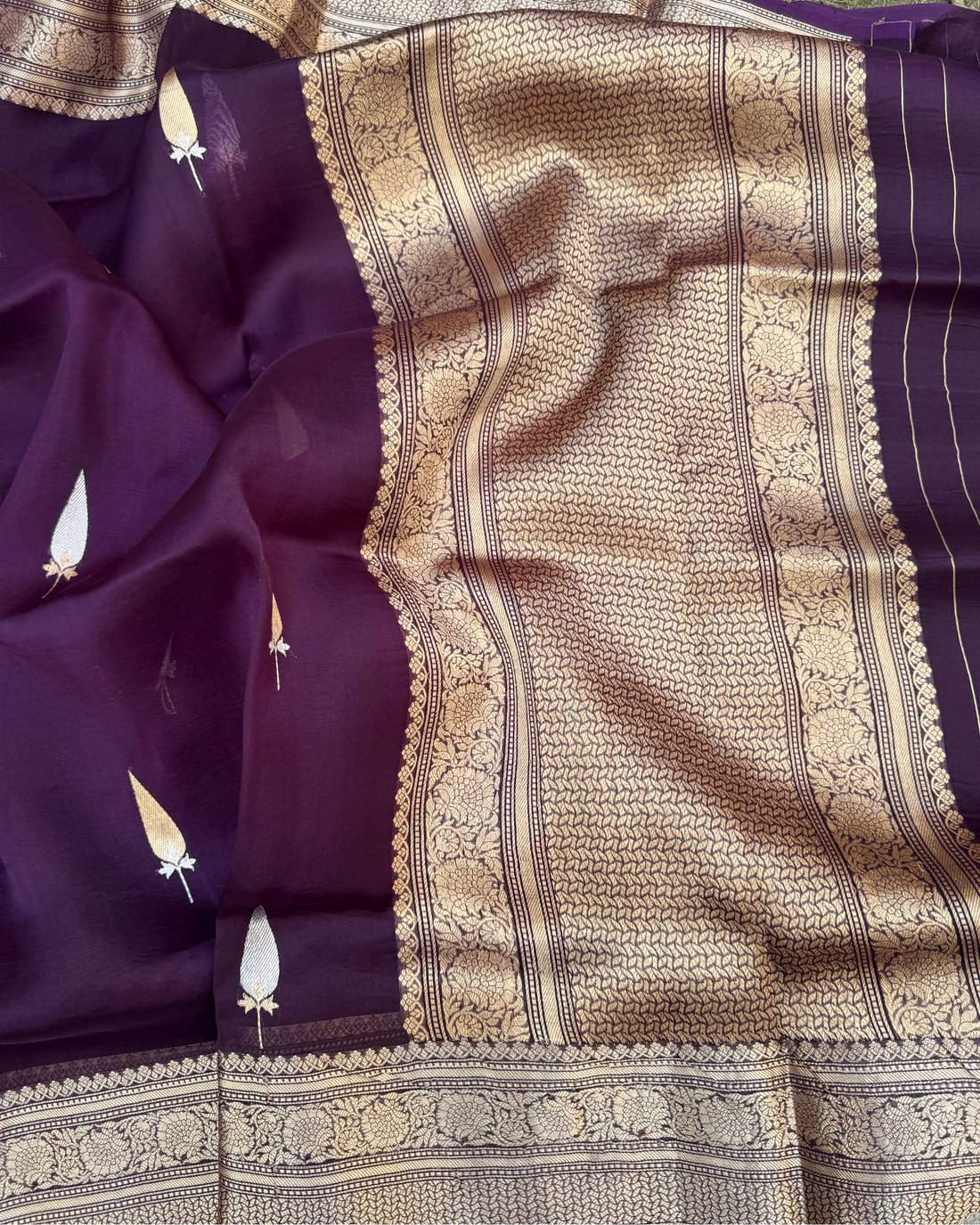 Close-up of shimmering zari booties on dark purple sheer Kora silk saree