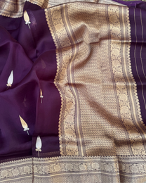 Close-up of shimmering zari booties on dark purple sheer Kora silk saree
