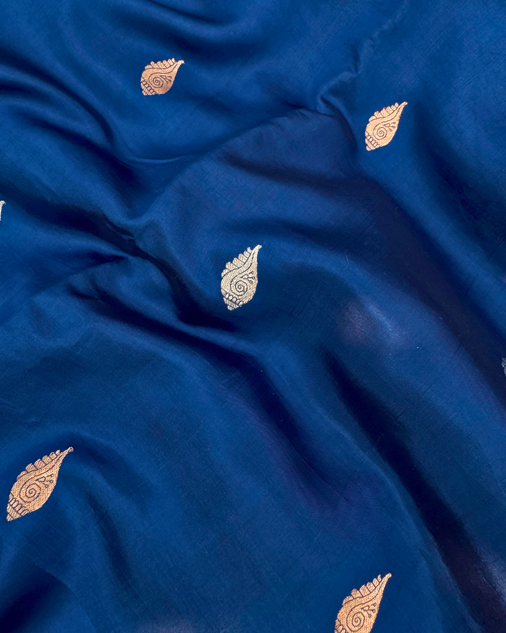 Draped pleats showing rich fluid texture of deep sea blue Banarasi saree