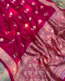 Close-up of delicate zari floral motifs on dark pink Mulberry silk fabric
