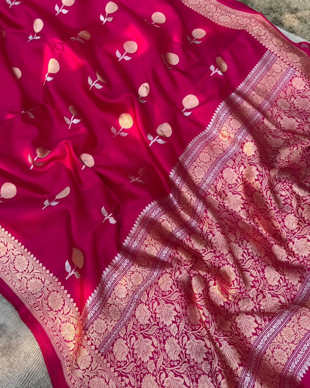 Close-up of delicate zari floral motifs on dark pink Mulberry silk fabric
