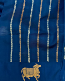 Sacred motifs and artistic border detail on deep sea blue soft silk saree