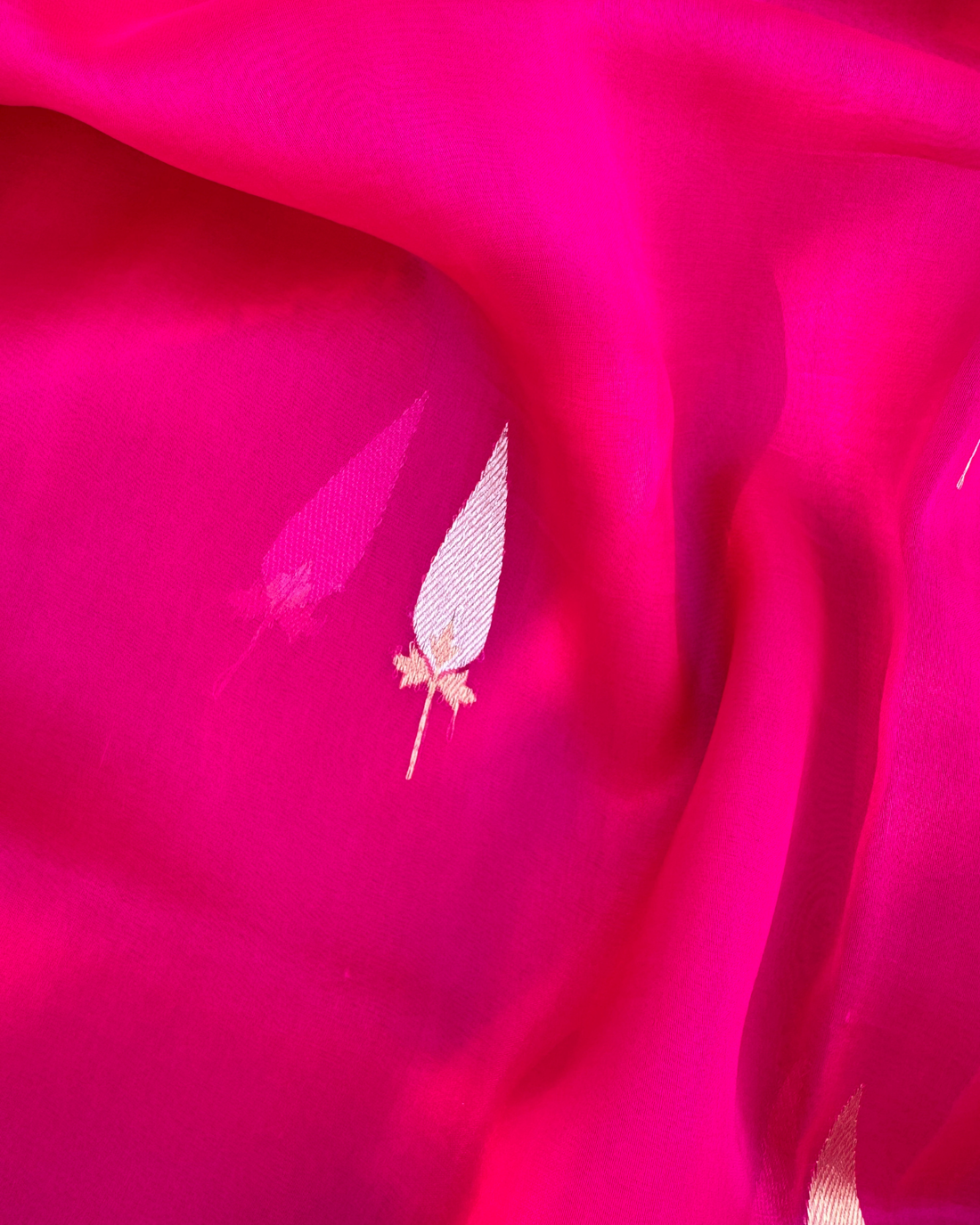 Close-up of shimmering zari Kadwa motifs on pink sheer Kora silk