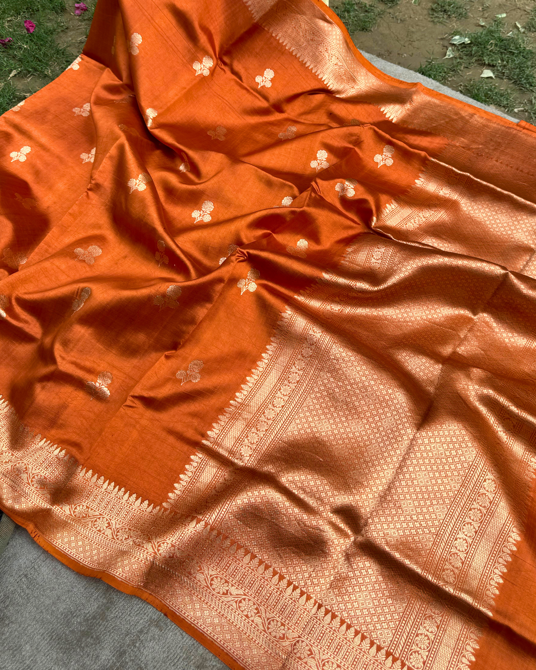 Close-up of intricate woven texture on dusty orange Mulberry soft silk saree