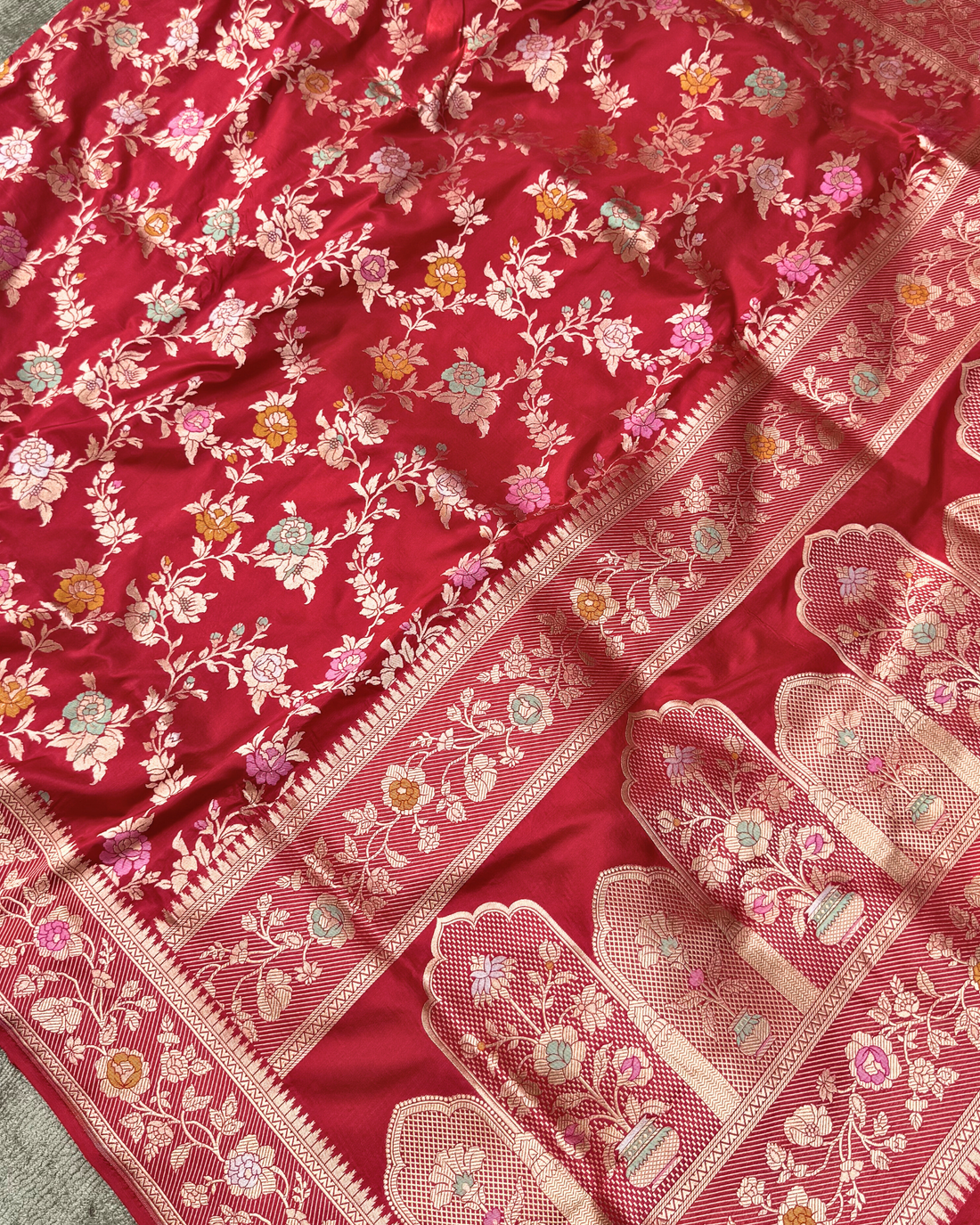 Close-up of dense traditional floral Jangla jaal on red pure Katan silk