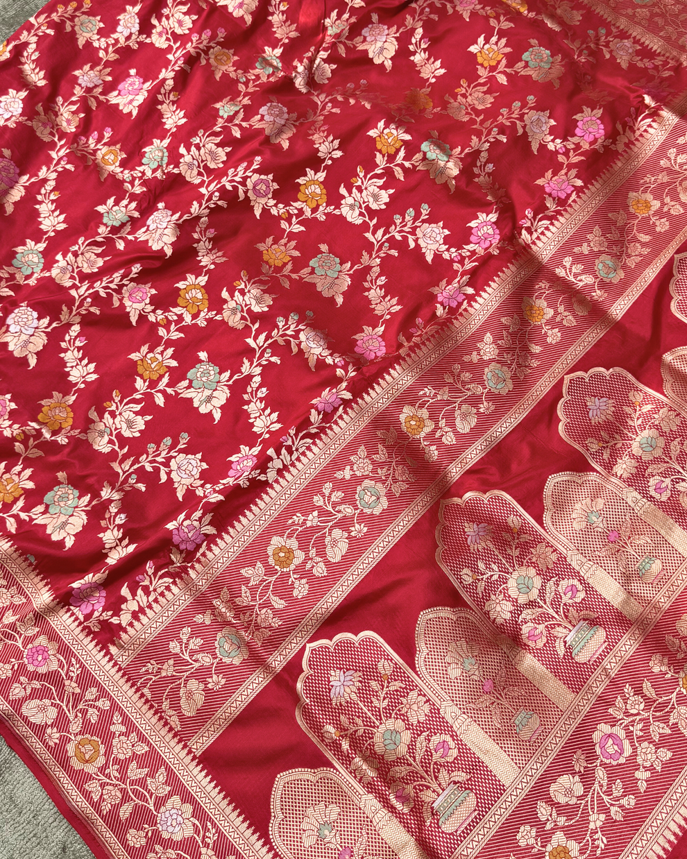 Close-up of dense traditional floral Jangla jaal on red pure Katan silk