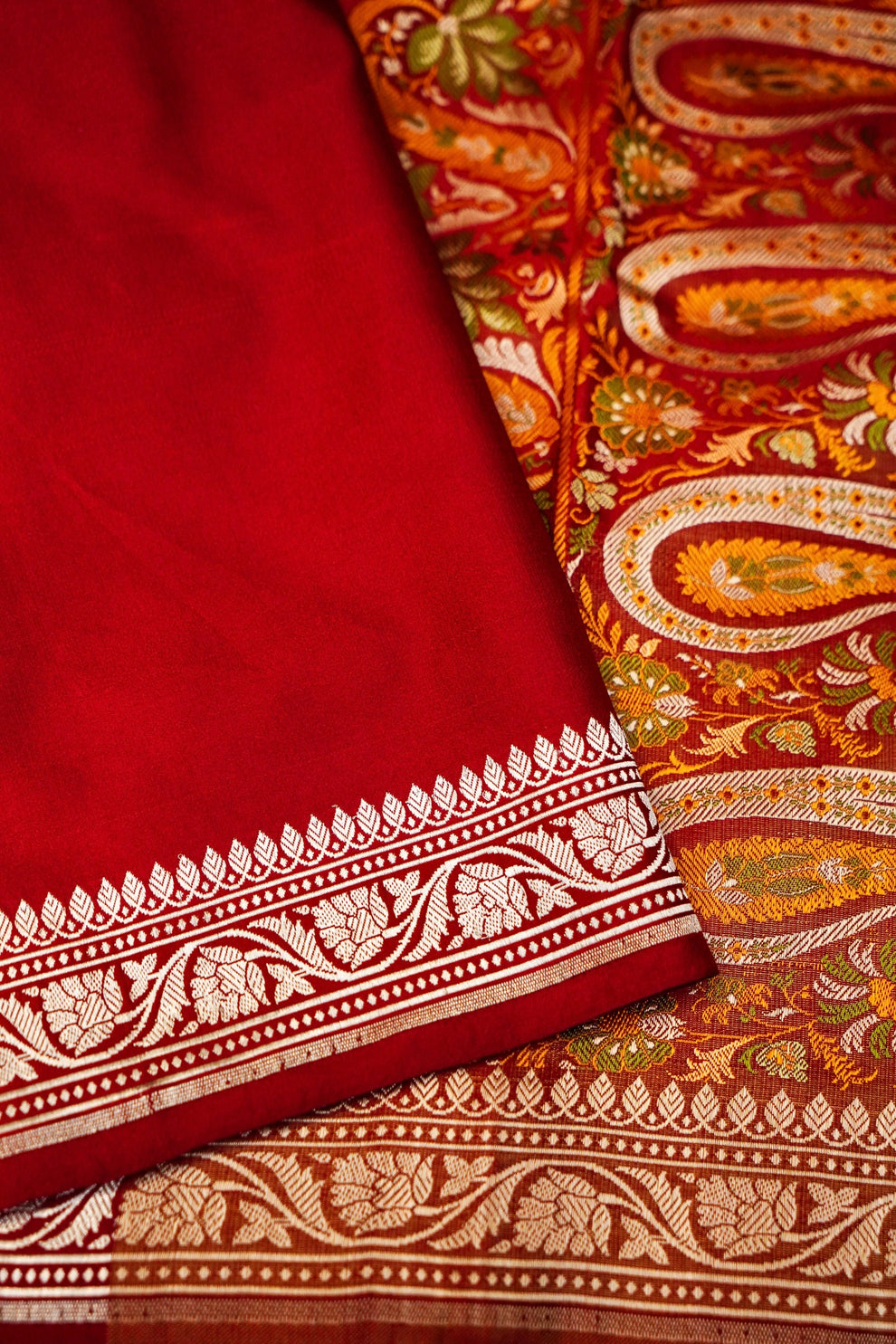 Close-up of traditional Banarasi motifs on red Mashru silk handloom fabric