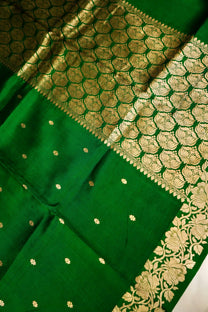 Close-up of small golden zari motifs and green Mulberry Katan silk weave