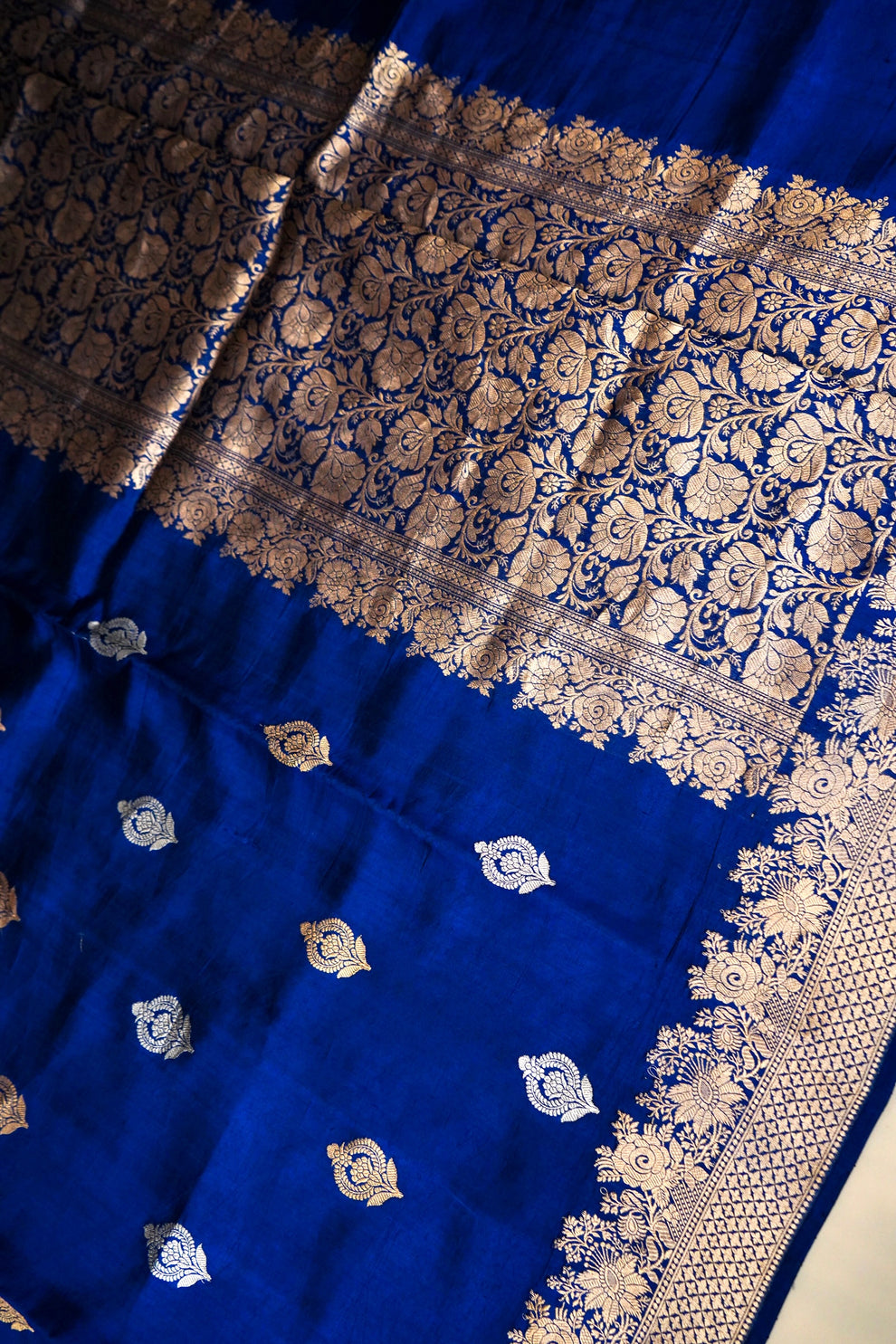 Close-up of individually woven Kadwa zari flower motifs on royal blue silk